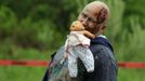 A zombie holds a doll in his mouth on the "Run for Your Lives" 5K obstacle course race in Amesbury, Massachusetts May 5, 2012. Runners face man-made and natural obstacles on the course, while being chased by zombies, who try to take "health" flags off the runners belts. REUTERS/Brian Snyder (UNITED STATES - Tags: SPORT SOCIETY) Published: Kvě. 5, 2012, 11:16 odp.