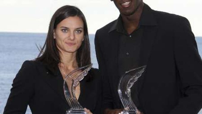 Usain Bolt a Jelena Isinbajevová pózují s trofejemi pro nejlepší atlety roku.