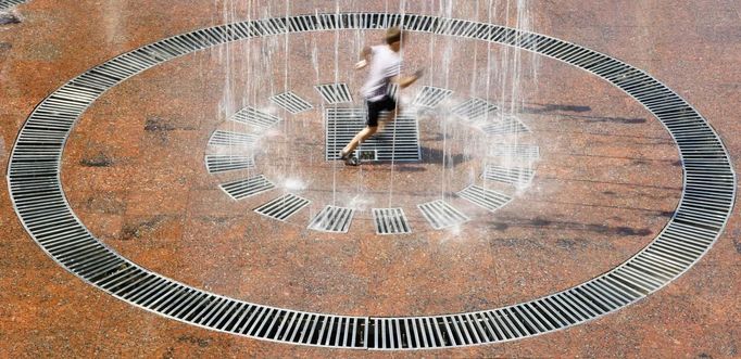 A boy plays in a fountain during a hot weather spell in the center of Kiev June 20, 2012. REUTERS/Anatolii Stepanov (UKRAINE - Tags: SOCIETY ENVIRONMENT) Published: Čer. 20, 2012, 12:37 odp.