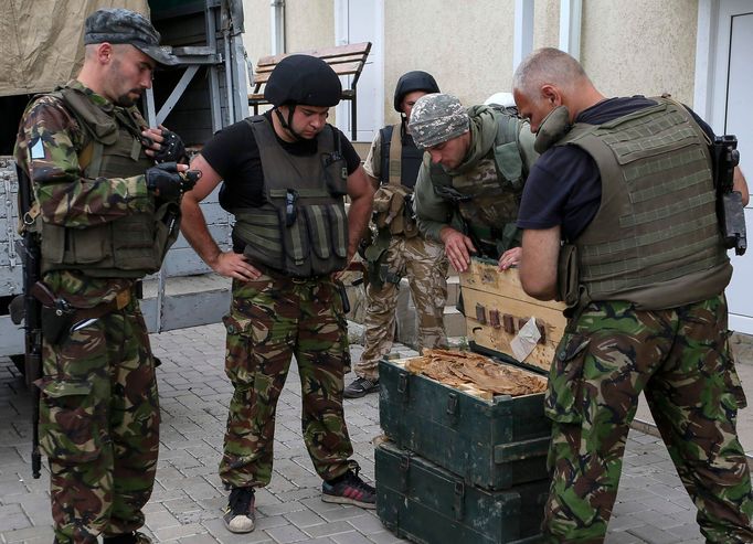 Příslušníci ukrajinské národní gardy prohlížejí zbraně, které získali od separatistů