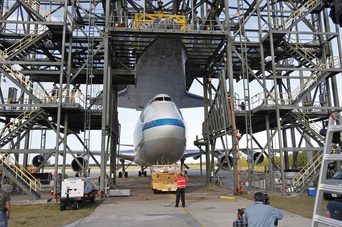 Space center workers watch as space shuttle Discovery is approached by a NASA 747 aircraft, which was towed into the Mate Demate facility at Kennedy Space Center in Cape Canaveral