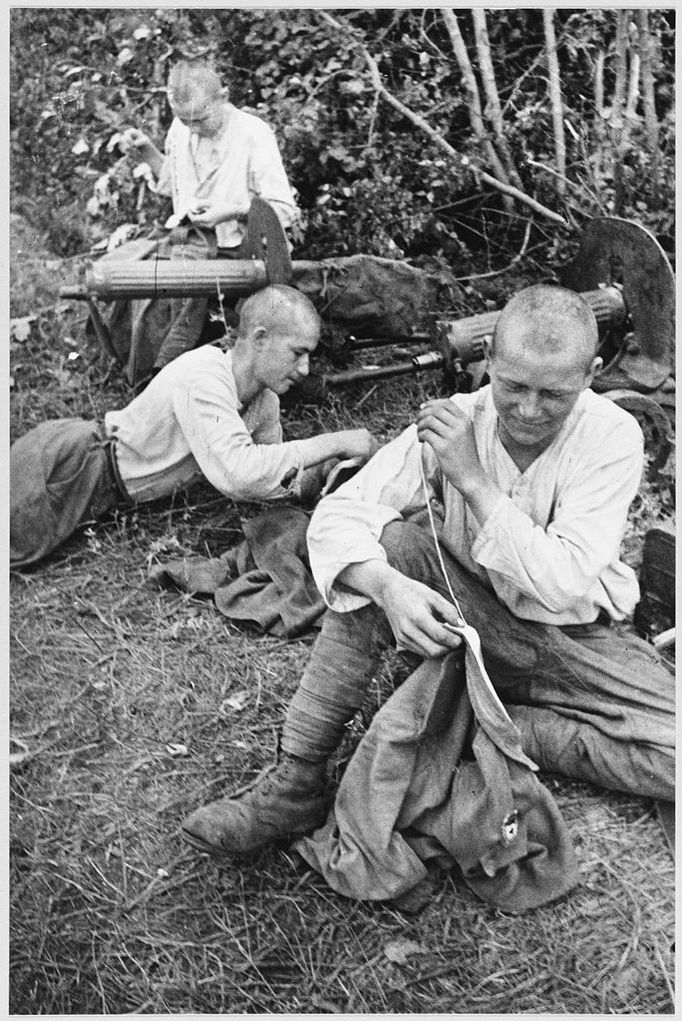 STALINGRAD - REPAIRS Soviet troops rest behind the front line and make repairs to their uniforms. Date: 1942-43 Source: Unattributed photograph MELEDIN COLLECTION