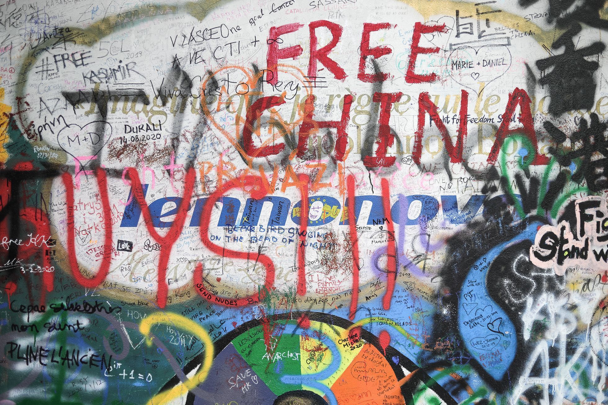 Lennonova zeď po třech měsících od malování - turisté, graffiti