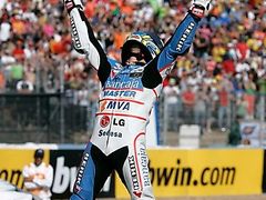 Maďar Gábor Talmacsi slaví vítězství v GP Španělska ve třídě do 125 ccm, v němž těsně porazil Lukáše Peška.