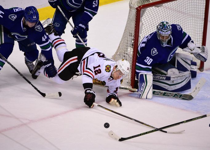 Chicago Blackhawks forward Tomas Fleischmann (12) reaches for the puck behind the net of Vancouver Canucks goaltender Ryan Miller (30)