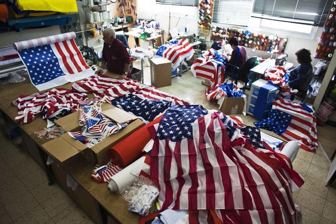 Workers at a factory in Kfar Saba near Tel Aviv sew U.S. flags that were ordered ahead of President Barack Obama's visit to Israel March 12, 2013. It was the most work the factory has had since Egyptian President Anwar Sadat visited Israel in 1977, owner Avi Marom said on Tuesday. The White House has yet to officially announce the dates for the trip, but Israeli news media have reported that Obama will arrive in Israel on March 20. REUTERS/Nir Elias (ISRAEL - Tags: POLITICS) Published: Bře. 12, 2013, 12:17 odp.