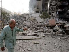 Muž míjí ruiny budov, které na předměstí Bejrútu zasáhly v noci na čtvrtek izraelské bomby.