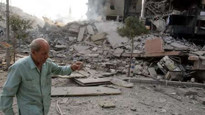 Muž míjí ruiny budov, které na předměstí Bejrútu zasáhly v noci na čtvrtek izraelské bomby.