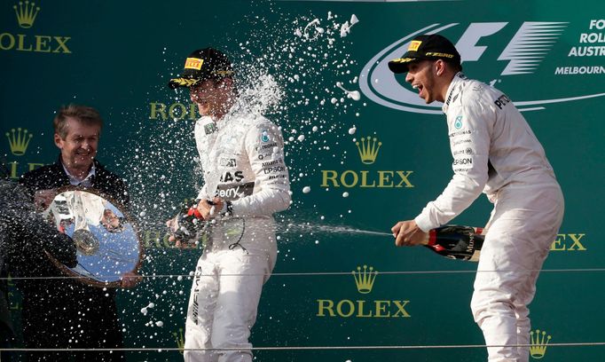 Race winner Mercedes Formula One driver Lewis Hamilton of Britain (R) sprays champagne next to team mate second placed Nico Rosberg of Germany (C) during the podium cerem