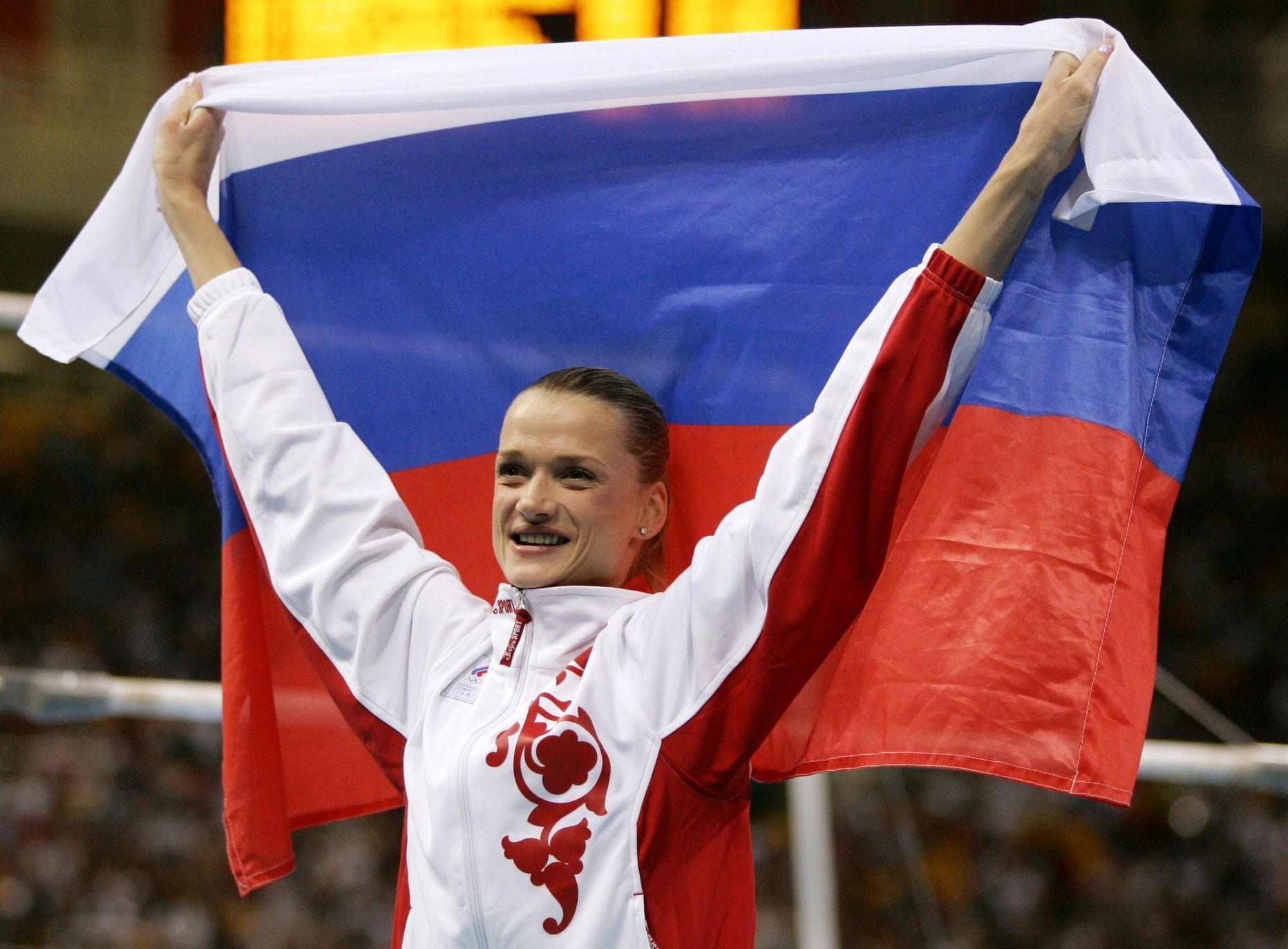Russia's Svetlana Khorkina celebrates with her national flag