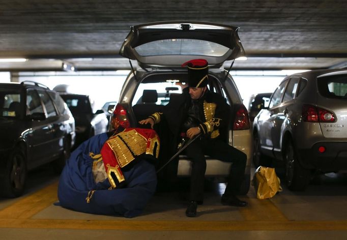 Marco Dilauro prepares his creations, costumes for the Venice Carnival, as he arrives by car in Venice January 25, 2013. Dilauro, 43, is a tax collector by day, but his real passion is making masks and costumes for the carnival. A resident of Como, northern Italy, he chooses fabrics, ribbons, lace and costume jewellery to make the period costumes after doing extensive research, and wears them at Carnival, which ends on the day before Ash Wednesday. Picture taken January 25, 2013. REUTERS/Alessandro Bianchi (ITALY - Tags: SOCIETY) Published: Led. 28, 2013, 12:06 dop.