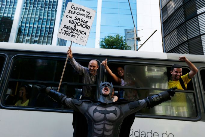 An anti-government demonstrator dressed as Batman yells slogans accompanied by passengers on a bus, during a protest against the 2014 World Cup in Rio de Janeiro June 12,