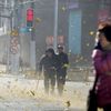 People walk along a street on a windy day in central Shanghai