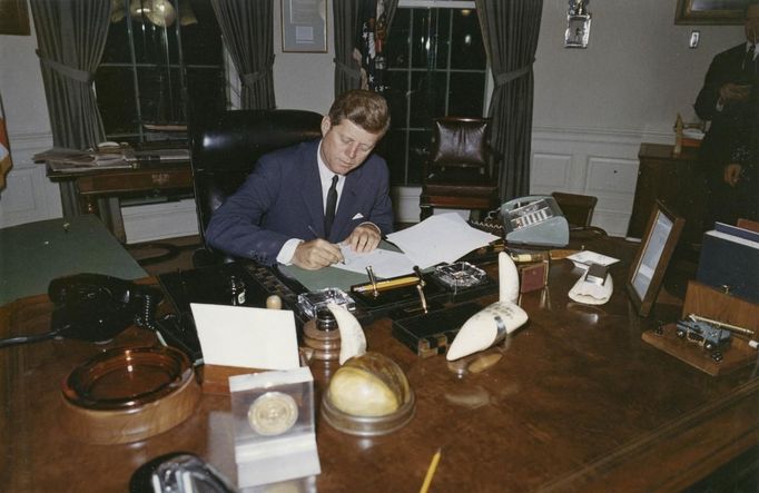 Former U.S. President John F. Kennedy signs a proclamation for the interdiction of the delivery of offensive weapons to Cuba during the Cuban missile crisis, at the White House in Washington in this handout photograph taken on October 23, 1962.