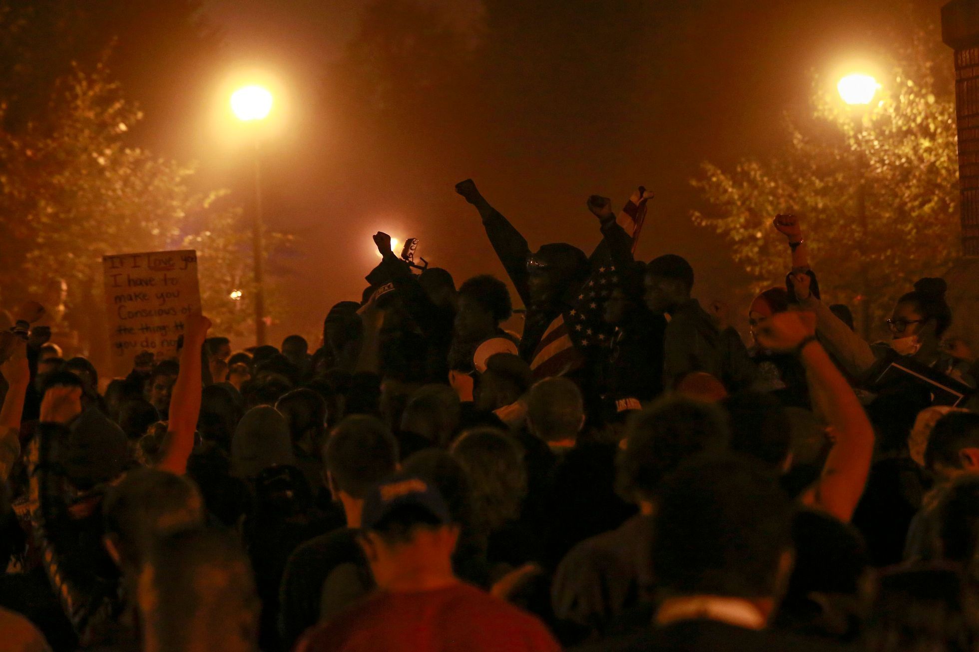 Demonstranti zvedají ruce při momentu ticha v areálu vysoké školy v St. Louis