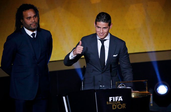 Real Madrid's James Rodriguez of Colombia gives a thumbs-up after receiving FIFA Puskas Award as former French player Christian Karembeu (L) looks on during the FIFA Ball