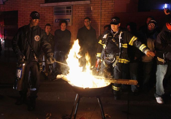 Members of the fire department extinguish a campfire built by people to keep warm in the aftermath of Hurricane Sandy in the lower east side in New York October 31, 2012. New York City and the sodden U.S. Northeast began an arduous journey back to normal on Wednesday after mammoth storm Sandy killed at least 64 people in a rampage that swamped coastal cities and cut power to millions. REUTERS/Carlo Allegri (UNITED STATES - Tags: SOCIETY ENVIRONMENT DISASTER) Published: Lis. 1, 2012, 3:28 dop.