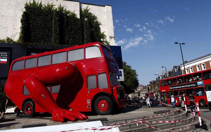 A London bus that has been transformed into a robotic sculpture by Czech artist David Cerny is assembled in front of the Czech Olympic headquarters in London July 22, 2012. The bus, which Cerny hopes could become an unofficial mascot of the London 2012 Olympic Games, does push-ups with the help of an engine powering a pair of robotic arms and the motion is accompanied by a recording of sounds evoking tough physical effort. It will be parked outside the Czech Olympic headquarters in London for the duration of the Games. REUTERS/Marika Kochiashvili (UNITED KINGDOM - Tags: SOCIETY SPORT OLYMPICS TRANSPORT) Published: Čec. 22, 2012, 6:02 odp.