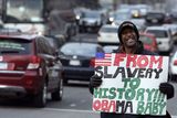 Z otroctví do historie! S takovým nápisem stál tento muž na rušné ulici Washingtonu den před inaugurací Baracka Obamy.
