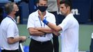 Sep 6, 2020; Flushing Meadows, New York, USA; Novak Djokovic of Serbia discusses with a tournament official after being defaulted for striking a lines person with a ball