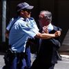 Policista drží muže, který se pokoušel dostat ke kavárně Lindt, kde ozbrojenec zadržuje rukojmí.