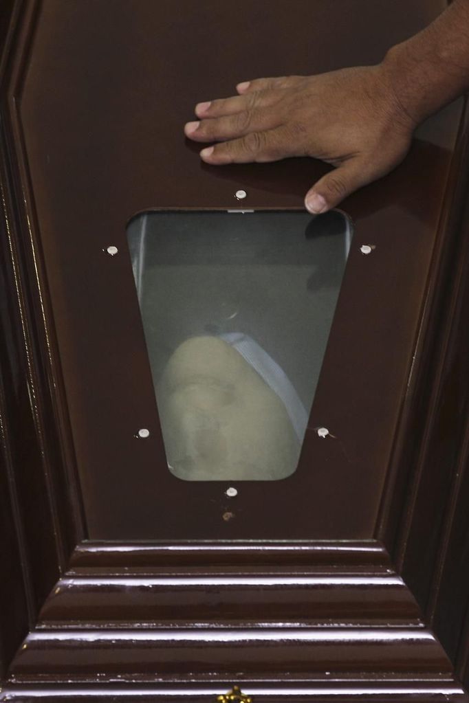 A members of the Movement of Landless Rural Workers (MST) places a hand on the coffin of architect Oscar Niemeyer at the Planalto Palace December 6, 2012. Niemeyer, a towering patriarch of modern architecture who shaped the look of modern Brazil and whose inventive, curved designs left their mark on cities worldwide, died late on Wednesday. He was 104. Niemeyer had been battling kidney and stomach ailments in a Rio de Janeiro hospital since early November. His death was the result of a lung infection developed this week, the hospital said, little more than a week before he would have turned 105. REUTERS/Ueslei Marcelino (BRAZIL - Tags: OBITUARY SOCIETY) Published: Pro. 6, 2012, 9:41 odp.