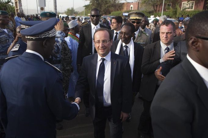 REFILE - CORRECTING IPTC CREDIT France's President Francois Hollande (C) greets Malian government officials while flanked by Malia's interim president Dioncounda Traore (white scarf) before speaking at the Independence Plaza in Bamako, Mali February 2, 2013. France will withdraw its troops from Mali once the Sahel state has restored sovereignty over its national territory and a U.N.-backed African military force can take over from the French soldiers, Hollande said on Saturday. REUTERS/Joe Penney (MALI - Tags: POLITICS CONFLICT) Published: Úno. 2, 2013, 8:25 odp.