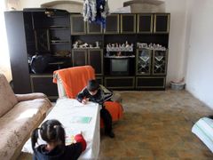 Čunek´s evicted Roma kids doing their homework in their new damp and no toilet home