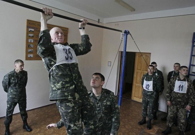 A recruit does pull-ups during a fitness test in an infantry unit camp based in Kiev October 15, 2012. REUTERS/Gleb Garanich (UKRAINE - Tags: MILITARY) Published: Říj. 15, 2012, 12:24 odp.