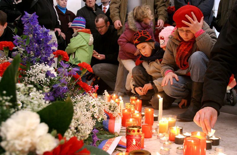 Děti zapalují svíčku u pomníku připomínající události 17.listopadu