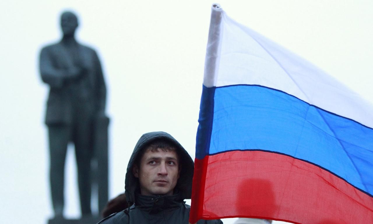Muž drží ruskou vlajku v Simferopolu