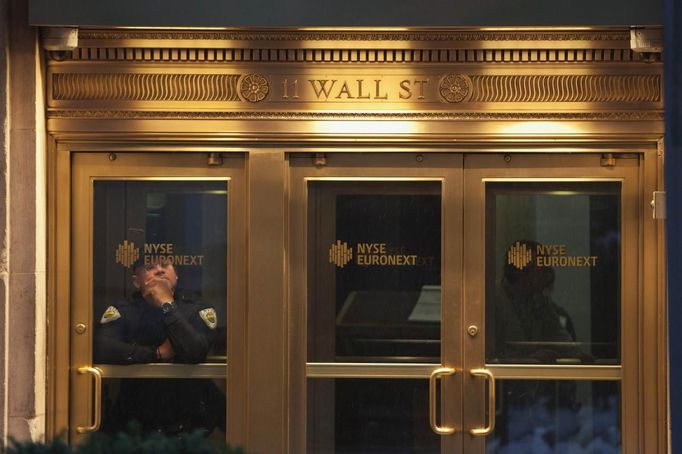 A security guard is seen at the New York Stock Exchange in downtown Manhattan as Hurricane Sandy makes its approach in New York October 29, 2012. Hurricane Sandy, the monster storm bearing down on the U.S. East Coast, strengthened on Monday after hundreds of thousands moved to higher ground, public transport shut down and the U.S. stock market suffered its first weather-related closure in 27 years. REUTERS/Andrew Kelly (UNITED STATES - Tags: ENVIRONMENT BUSINESS) Published: Říj. 29, 2012, 1:45 odp.