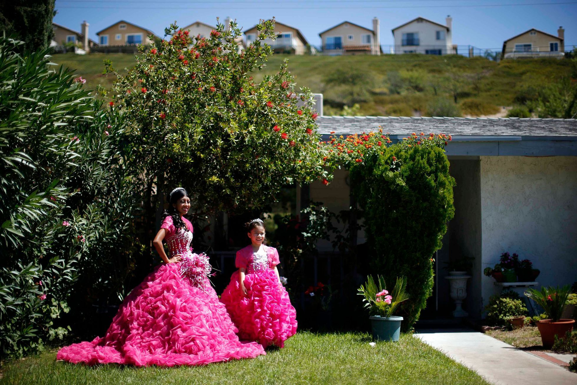 Mimi Pineda, whose parents are from El Salvador, stands outside her aunt's house with Maybelin Ramirez, before her quinceanera  in Santa Clarita, California