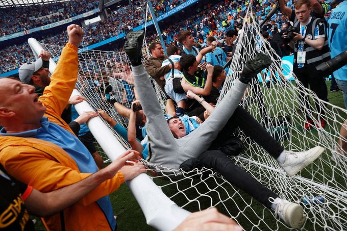 Fanoušci Manchesteru City slaví přímo na trávníku Etihad Stadium titul v anglické fotbalové lize