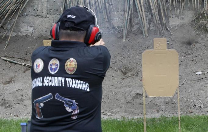 Jaime 'Jimmy' Santiago, a lower court judge in Manila, fires his service pistol during shooting practice with fellow court judges at a police firing range in Manila March 6, 2013. Jaime 'Jimmy' Santiago, a former police officer who headed a special weapons and tactics (SWAT) unit, now a lower court judges in Manila, favours arming Filipino judges to protect themselves from disgruntled litigants who can't accept decisions and criminal syndicates whose members were sent to jail. There had been cases of shootings inside courtrooms.Picture taken March 6, 2013. REUTERS/Romeo Ranoco (PHILIPPINES - Tags: POLITICS CRIME LAW) Published: Dub. 4, 2013, 11:13 dop.