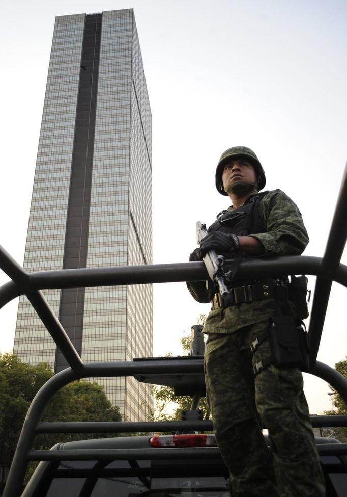 A soldier stands guard near the headquarters of state oil giant Pemex in Mexico City January 31, 2013. A powerful explosion rocked the Mexico City headquarters of state oil giant Pemex on Thursday, killing at least 14 people and injuring 100 others.The blast hit the lower floors of the downtown tower block, throwing debris into the streets and sending workers running outside. Interior Minister Miguel Angel Osorio Chong said the blast killed at least 14 people and injured 100. It was not yet clear what caused the explosion, and the death toll could still rise, he added. REUTERS/Alejandro Dias (MEXICO - Tags: DISASTER ENERGY POLITICS MILITARY) Published: Úno. 1, 2013, 2:16 dop.