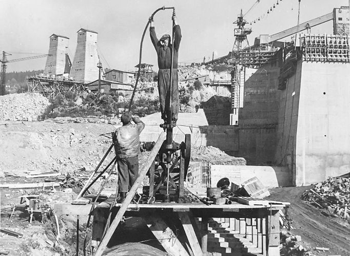 Fotografie ukazuje výstavbu vodní nádrže a elektrárny Lipno, významného díla z roku 1959, které dodává energii a poskytuje rekreační možnosti.