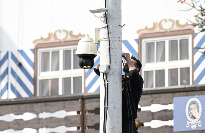 A worker installs a surveillance camera in front of a beer tent ahead of the 189th Oktoberfest, the world's largest beer festival in Munich, Germany, September 11, 2024.