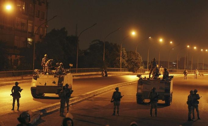 Army soldiers take their positions on the bridge towards members of the Muslim Brotherhood and supporters of Mursi standing guard around Cairo University and Nahdet Misr Square in Giza, on the outskirts of Cairo July 3, 2013. Egypt's armed forces overthrew elected Islamist President Mohamed Mursi on Wednesday and announced a political transition with the support of a wide range of political, religious and youth leaders. A statement published in Mursi's name on his official Facebook page after head of Egypt's armed forces General Abdel Fattah al-Sisi's speech said the measures announced amounted to "a full military coup" and were "totally rejected". REUTERS/Louafi Larbi (EGYPT - Tags: POLITICS CIVIL UNREST MILITARY) Published: Čec. 3, 2013, 8:33 odp.