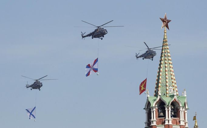 Russian helicopters carrying military insignias fly near the Spasskaya tower of the Kremlin during the general rehearsal for the forthcoming Victory parade on Moscow's Red Square May 6, 2012. Russia celebrates its 67th anniversary of victory over Nazi Germany on May 9. REUTERS/Tatyana Makeyeva (RUSSIA - Tags: ANNIVERSARY POLITICS SOCIETY TRANSPORT MILITARY) Published: Kvě. 6, 2012, 9:02 dop.