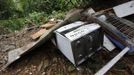 Broken appliances and building material lay in a heap outside a house at Scorpion Alley, as part of the destruction from a mudslide following heavy showers caused by the passing of Tropical Storm Isaac, in Carenage, about 10 km (6 miles) west of the capital Port-of-Spain August 23, 2012. Tropical Storm Isaac unleashed heavy rain and winds off Puerto Rico and the Virgin Islands as it moved across the Caribbean on Thursday and could strengthen into a hurricane before tearing across the Dominican Republic and Haiti. REUTERS/Andrea De Silva (TRINIDAD AND TOBAGO - Tags: DISASTER ENVIRONMENT) Published: Srp. 24, 2012, 2:33 dop.