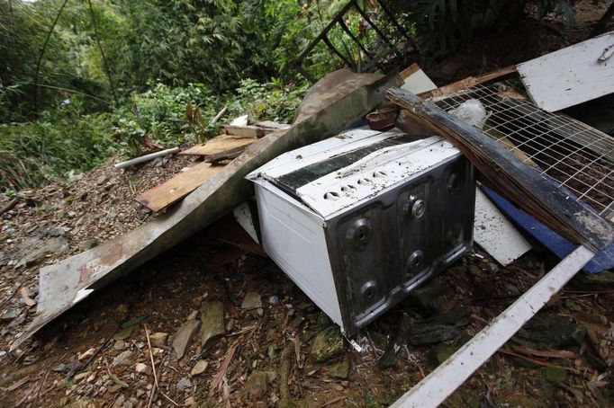 Broken appliances and building material lay in a heap outside a house at Scorpion Alley, as part of the destruction from a mudslide following heavy showers caused by the passing of Tropical Storm Isaac, in Carenage, about 10 km (6 miles) west of the capital Port-of-Spain August 23, 2012. Tropical Storm Isaac unleashed heavy rain and winds off Puerto Rico and the Virgin Islands as it moved across the Caribbean on Thursday and could strengthen into a hurricane before tearing across the Dominican Republic and Haiti. REUTERS/Andrea De Silva (TRINIDAD AND TOBAGO - Tags: DISASTER ENVIRONMENT) Published: Srp. 24, 2012, 2:33 dop.