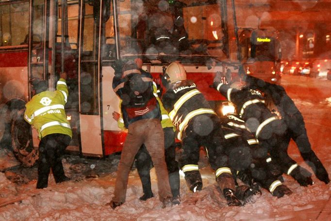 Hasiči v Praze 6 ulici Makovského vyprošťují autobus, který se zasekl v tramvajových kolejích