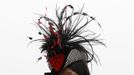 A woman poses in her hat on Ladies Day, the second day of racing at the Cheltenham Festival horse racing meet in Gloucestershire, western England March 14, 2012.