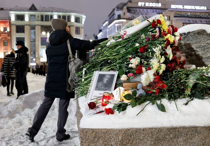 Žena pokládá květiny k památníku obětem politických represí po smrti ruského opozičního předáka Alexeje Navalného v Moskvě.