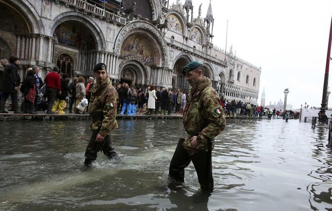 Italian army soldiers patrol in St. Mark Square during a period of seasonal high water in Venice October 27, 2012. The water level in the canal city rose to 127 cm (50 inches) above the normal level, according to the monitoring institute. REUTERS/Manuel Silvestri (ITALY - Tags: MILITARY ENVIRONMENT SOCIETY TRAVEL) Published: Říj. 27, 2012, 12:31 odp.