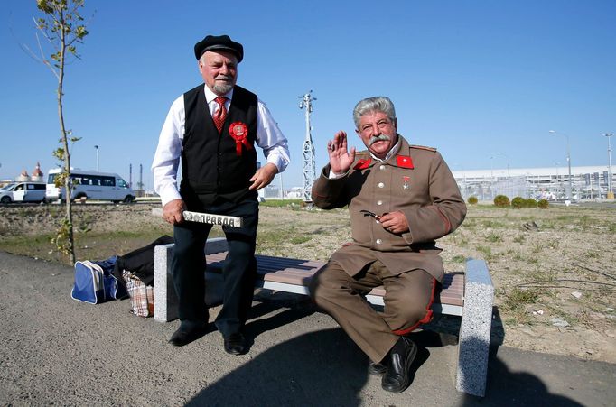 Men dressed as Soviet state founder Vladimir Lenin and Soviet leader Joseph Stalin pose for a picture in front of the paddock before the start of the Russian F1 Grand Pri