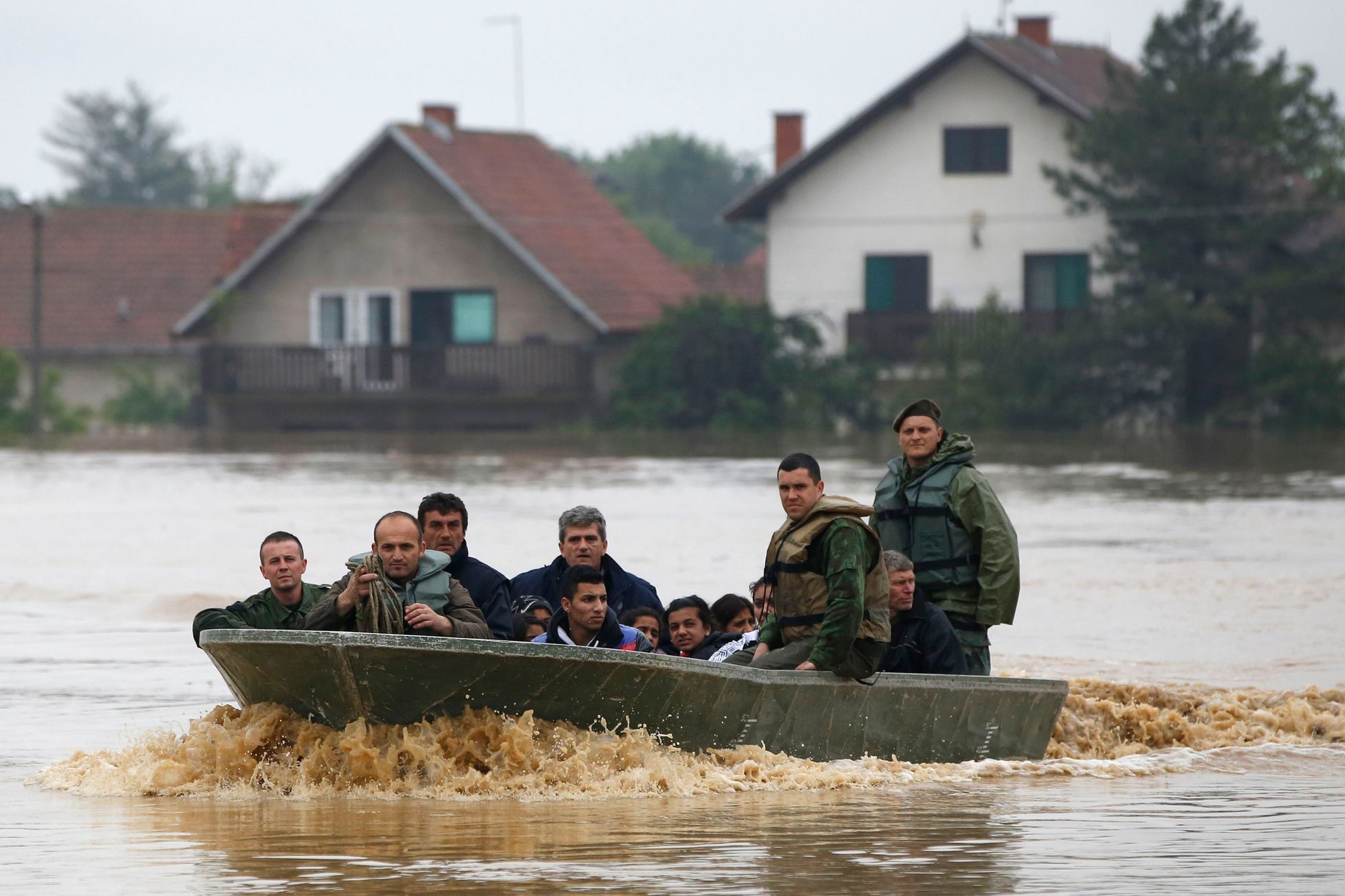 People sit in a boat after being evacuated from their flooded houses by Serbian army soldiers in the town of Obrenovac, east from Belgrade