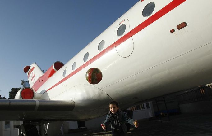 Children play next to a plane at a kindergarten in the town of Rustavi some 25 km (15 miles) south of Tbilisi, October 31, 2012. The fully functional Soviet-era Yakovlev Yak-40 plane has been installed in the kindergarten courtyard and refurbished as a children's playground. REUTERS/David Mdzinarishvili (GEORGIA - Tags: EDUCATION SOCIETY) Published: Říj. 31, 2012, 11:15 dop.