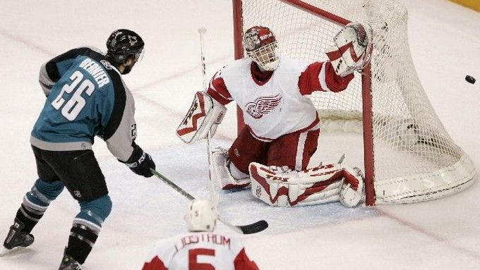 Detrotiský gólman Dominik Hašek chytá šanci Stevu Bernierovi ze San Jose v šestém zápase čtvrtfinále play off NHL.